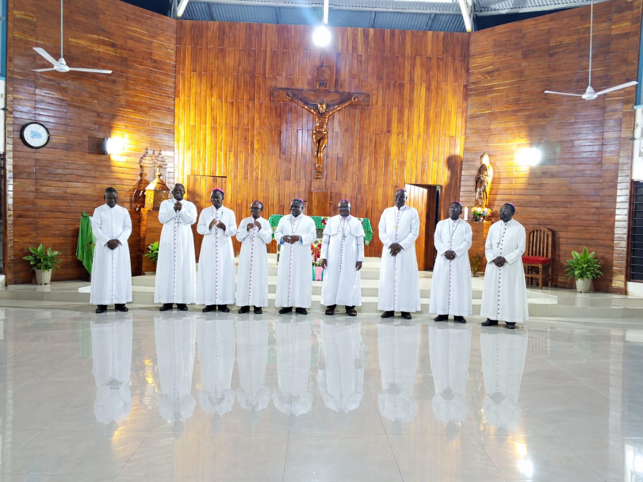 Les évêques, en soutane blanche, alignés devant l’autel et le crucifix de la chapelle des Sœurs à Kara